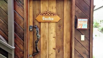 Uma porta de madeira com uma placa que diz 'Gecko' e um pequeno quadro na parede.