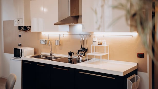 A modern kitchen with a central island, stainless steel appliances, and built-in cabinetry.