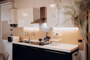 A modern kitchen with a central island, stainless steel appliances, and built-in cabinetry. - Feel Welcome Apartment (sleeps 4) in Negrar di Valpolicella, central Verona area (Negrar di Valpolicella)
