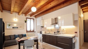 A modern kitchen with dark cabinets, a central island, and a dining area with a table and chairs.