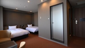 Una habitación de hotel con dos camas, un escritorio, una silla y un armario.