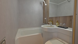 A bathroom with a bathtub, a sink, and a mirror.