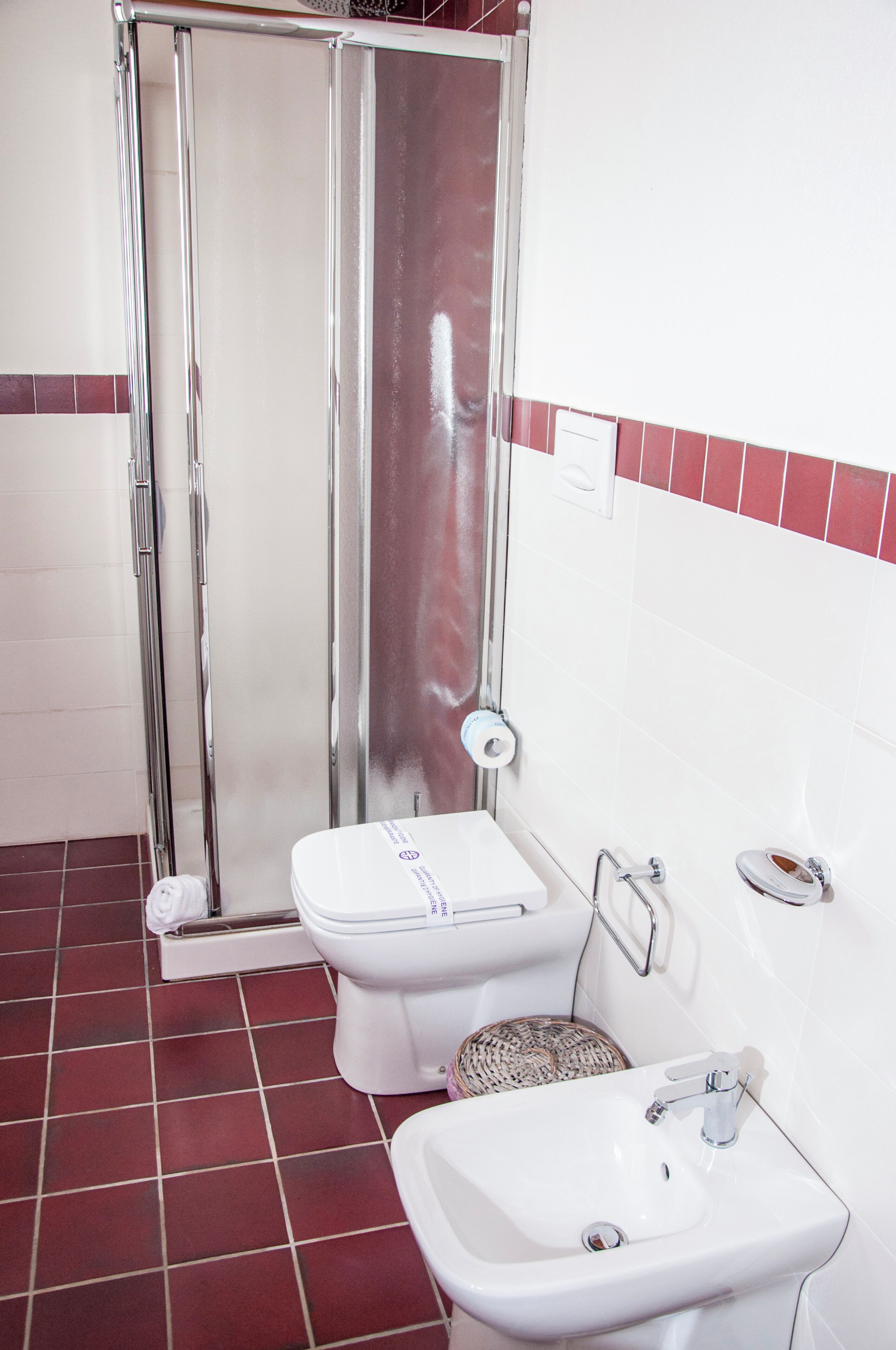 A bathroom with a shower, toilet, and sink.