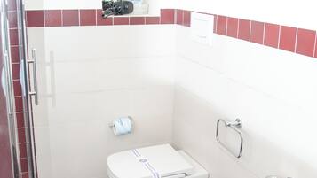 A bathroom with a toilet, bidet, and sink.