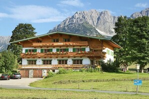 Ein traditionelles Chalet mit Balkon, umgeben von Bergen.