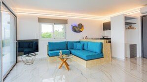 Ein modernes Wohnzimmer mit einem Ecksofa, einem Glastisch und einer an der Wand befestigten Uhr.