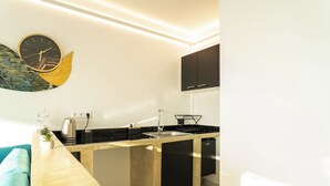 Eine moderne Küche mit schwarzem Arbeitsplatz, einem Edelstahlkocher und einem Schrank über der Spüle.