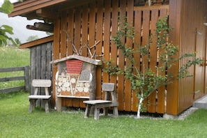 Ein rustikales Holzgebäude mit einer kleinen Holzbank und einem Baum davor.