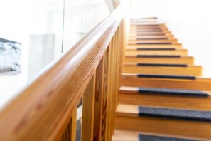 Eine Holztreppe mit Handlauf, die nach oben führt.