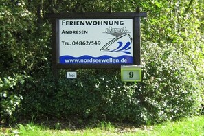 Schild für ein Bed and Breakfast namens 'FERIENWOHNUNG ANDRESEN' mit Kontaktinformationen und einer Website.