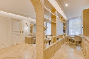 A modern interior with a herringbone floor, wooden shelving, a seating area, and a large window. - A Wonderfull 1-BR/2BA - Champs Elysées (Paris)