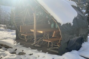 Eine Holzhütte mit Bänken und einem mit Schnee bedeckten Dach.