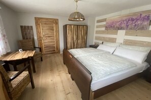 Ein Schlafzimmer mit einem hölzernen Bett, einem Schreibtisch und einem Stuhl.
