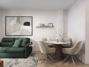 Ein modernes Wohnzimmer mit einem grünen Sofa, einem runden Esstisch mit Stühlen, einem Couchtisch und einem an der Wand befestigten abstrakten Gemälde.