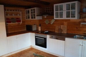 Een keuken met witte kastjes, een vaatwasser, een oven en een spoelbak.