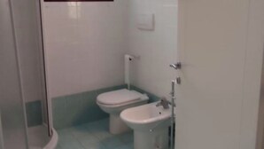 Un bany petit amb vàter, bidet i plat de dutxa.