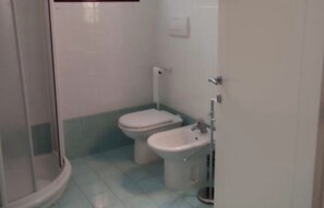 A small bathroom with a toilet, bidet, and a shower enclosure. - The Little Apartment Near the Sea (Riccione)