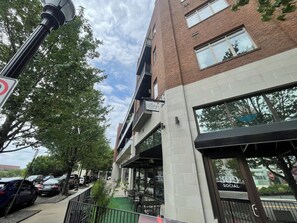 A multi-story building with a brick facade, large windows, and a sign indicating a social space. - Studio Social - Steps from Stadium! & Pet Friendly (Atlanta)