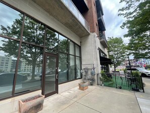 A modern building with large glass windows, a brick facade, and a metal fence. - Studio Social - Steps from Stadium! & Pet Friendly (Atlanta)