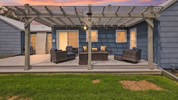 A covered patio with outdoor furniture and a pergola structure. - Waldo Blue Haven KC Home With Pergola Deck (Kansas City)