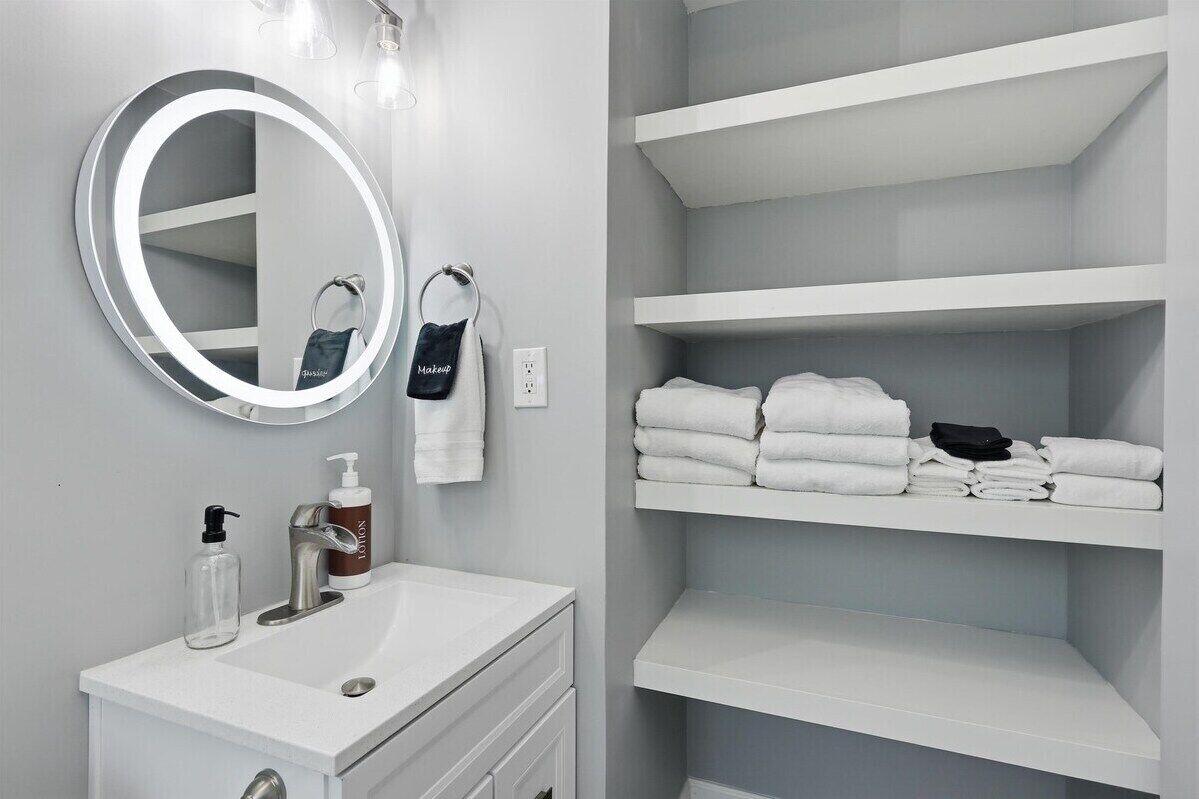 Open shelving stocked with fresh towels, Tommy Bahama lotion and make up towels for added convenience.
