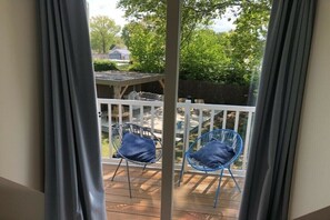 Ein Balkon mit zwei Stühlen und einer Holzterrasse.