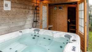 A wooden cabin with a hot tub, wooden walls, and a door leading to a bathroom. - Chic Holiday Home in Friesland for 6 (Tzummarum)