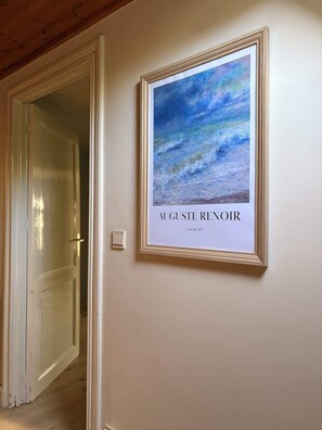 Ein gerahmtes Seestück von Auguste Renoir an der Wand.