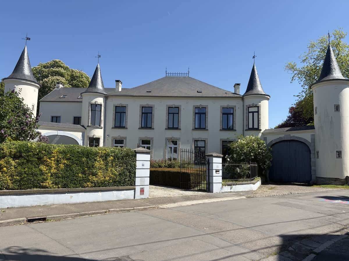 Een groot, wit gebouw met meerdere torens en een hekpoort.