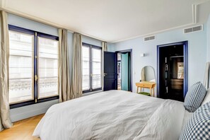 Ein Schlafzimmer mit einem großen Bett, einem Schreibtisch, einem Stuhl und einem Kleiderschrank.