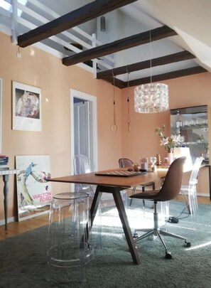 A modern dining area with a wooden table, clear chairs, a glass coffee table, and a hanging light fixture. - 2-story apartment near City Beach in Østerbro (København)