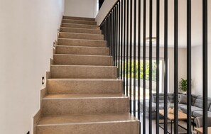 A staircase with a modern design, leading to a living area with a sofa and a coffee table. - Nice home in Privlaka (Privlaka)