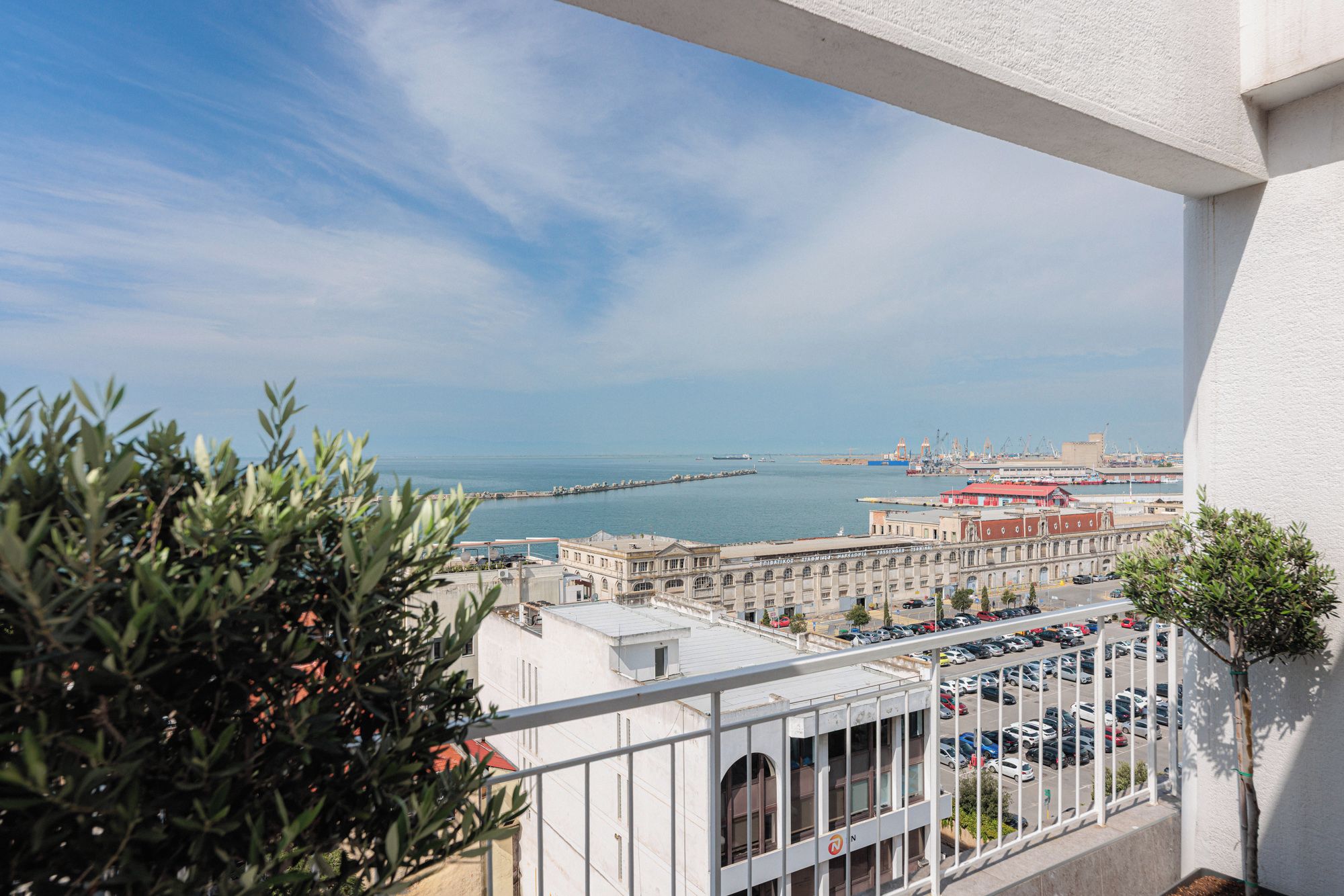 A balcony with a view of a port and buildings.