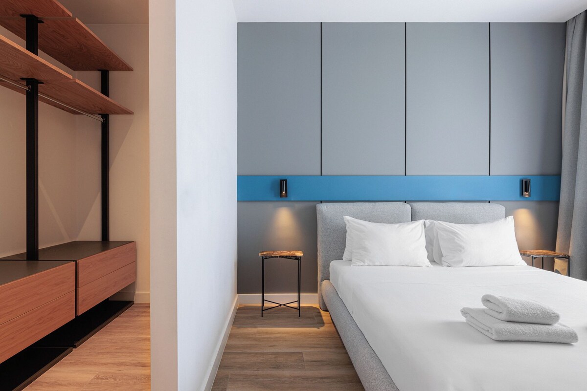 A modern bedroom with a bed, bedside tables, and a built-in bench.