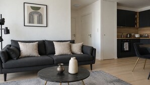 A modern living room with a dark grey sofa, a round coffee table, and a minimalist decor. - Magnifique 2 pieces a Issy lesMoulineaux (Vanves)