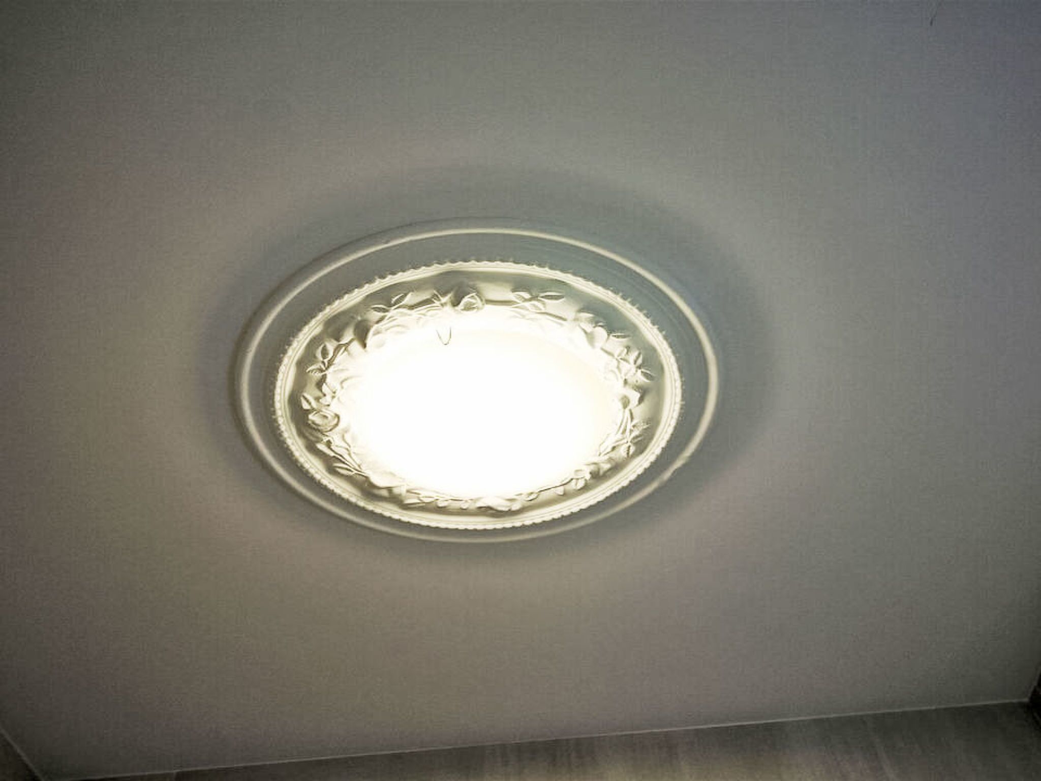 Un plafond orné d’un luminaire circulaire.