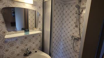 A bathroom with a shower, sink, and mirror.