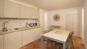 A compact kitchen with a sink, coffee maker, microwave, and a clock on the wall. - Casa Gloria - in the center of San Zeno di Montagna (San Zeno di Montagna)
