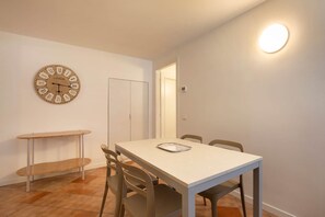 A dining area with a table, chairs, a clock, and a light fixture. - Casa Gloria - in the center of San Zeno di Montagna (San Zeno di Montagna)