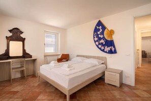 A bedroom with a bed, a desk, a chair, a nightstand, a mirror, and a wall-mounted fan. - Casa Gloria - in the center of San Zeno di Montagna (San Zeno di Montagna)