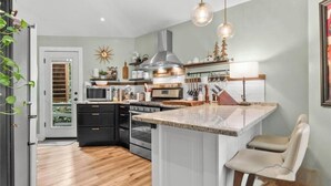 Une cuisine moderne dotée d’un îlot central, d’un four encastré et de divers appareils électroménagers.