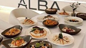 A dining area with a table set for a meal, a reception desk, and a sign with the word 'ALBA'. - Corp Yanbu Hotel B1 (Yanbu)