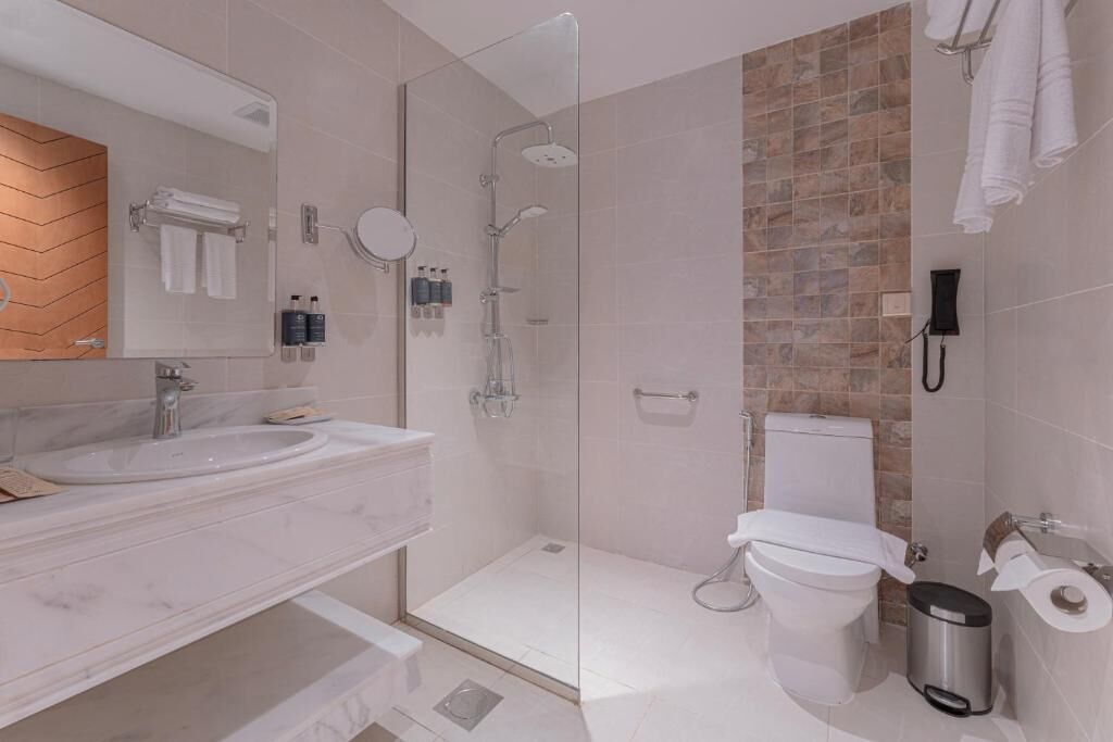 Een aparte badkuip en douche, een haardroger, pantoffels, handdoeken