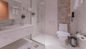 Een aparte badkuip en douche, een haardroger, pantoffels, handdoeken