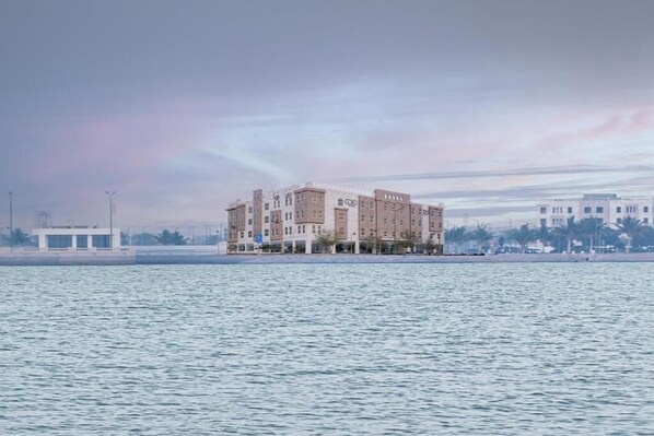 A multi-story hotel with a waterfront view, located near a body of water.