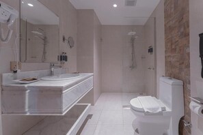 Grand suite, uitzicht op de stad | Badkamer | Een aparte badkuip en douche, een haardroger, pantoffels, handdoeken