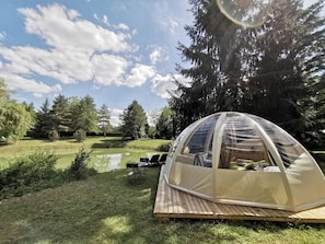 A dome tent with a wooden deck, a pond, and trees in the background. - Holiday Home 'Gite La Chenevelle' with Private Terrace, Private Garden and Wi-Fi (Chitenay)