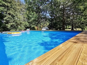 A clear blue pool surrounded by trees, with a wooden deck and a diving board. - Holiday Home 'Gite La Chenevelle' with Private Terrace, Private Garden and Wi-Fi (Chitenay)