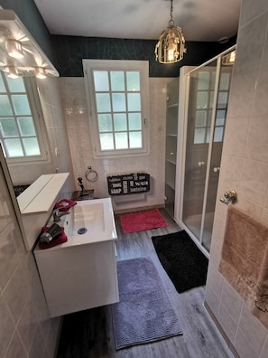 A modern bathroom with a sink, mirror, towel rack, shower, and a sign with bathroom amenities. - Holiday Home 'Gite La Chenevelle' with Private Terrace, Private Garden and Wi-Fi (Chitenay)