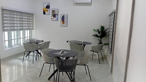 A modern interior with a dining area, air conditioning, and artwork on the walls. - Devon's Stylish 1BR Apartment + Pool, Apo Resettlement Abuja (Abuja)